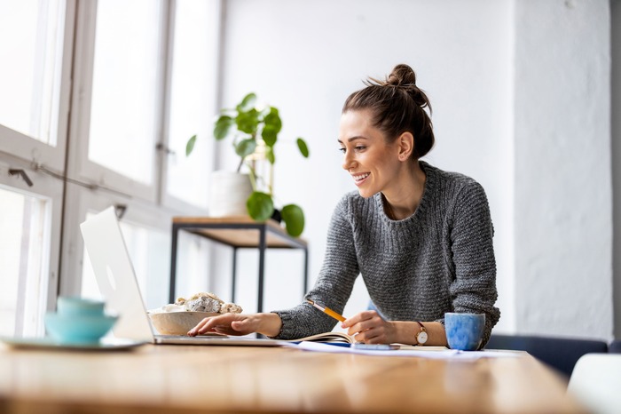 Woman smiling while using a laptop