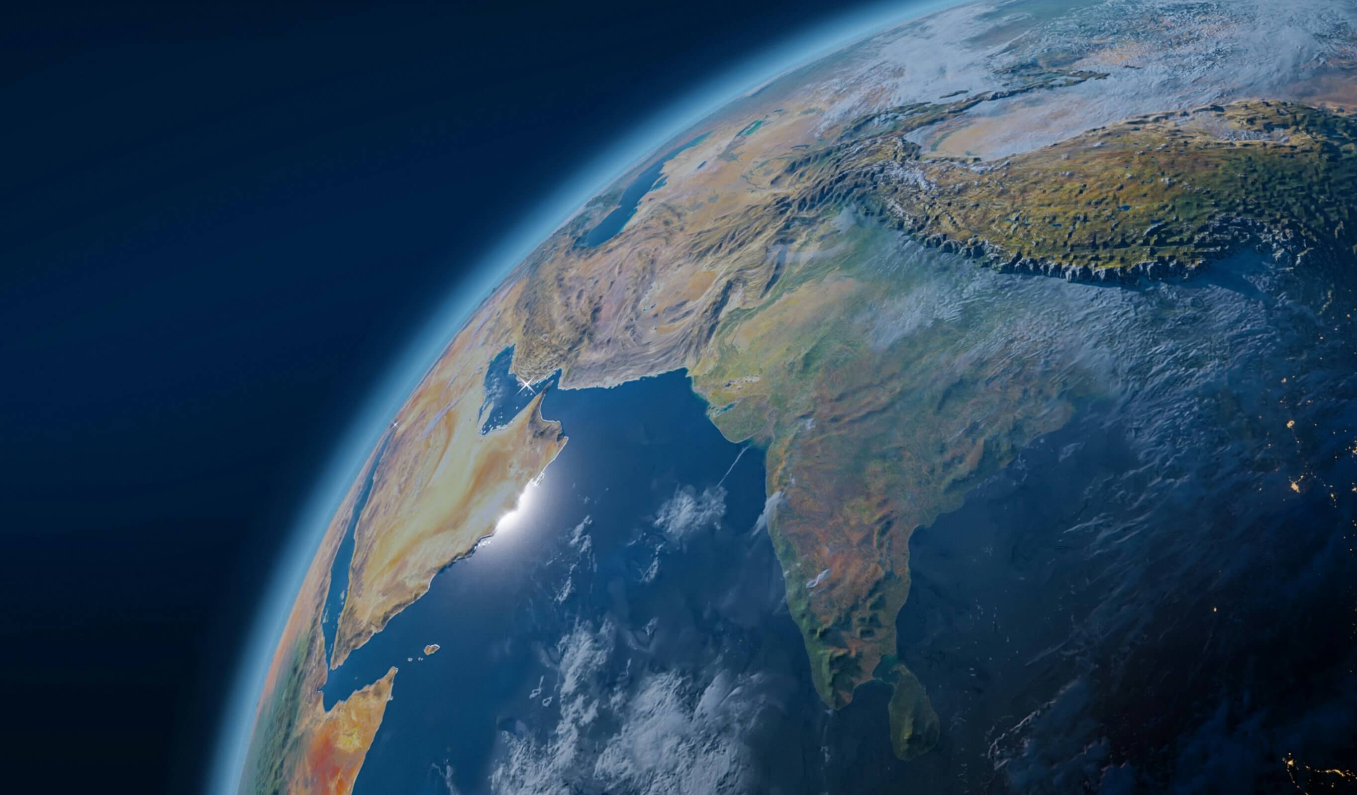 A view of Earth from space, showcasing a vibrant blue sky and the planet's curvature against the dark backdrop of space.